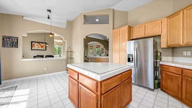 7302 Little Easy St, Sparks, NV 89436 - kitchen with tile counters, stainless steel fridge with ice dispenser, lofted ceiling, arched walkways, and light tile patterned flooring