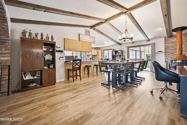 202 Summit Ave, Winnemucca, NV 89445 - dining area with a chandelier, light wood-type flooring, a textured ceiling, and a wood stove