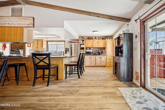 202 Summit Ave, Winnemucca, NV 89445 - kitchen with light brown cabinets, a peninsula, beam ceiling, light wood finished floors, and a breakfast bar area