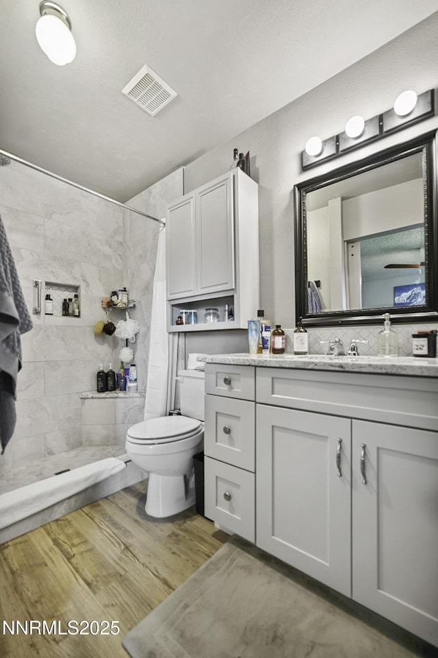 202 Summit Ave, Winnemucca, NV 89445 - bathroom with tiled shower, vanity, and wood finished floors