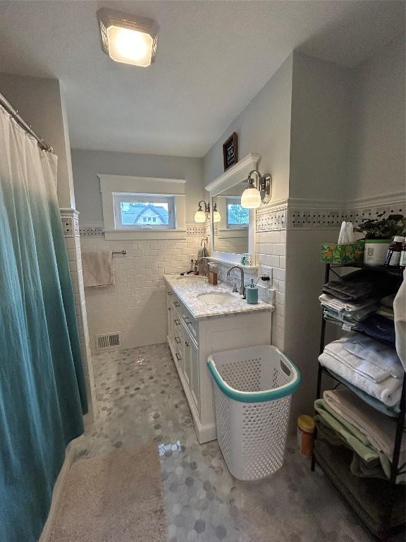 563 W 9th St, Erie, PA 16502 - full bathroom with tile walls, a wainscoted wall, and double vanity
