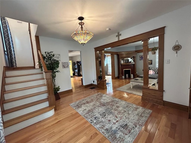 563 W 9th St, Erie, PA 16502 - foyer featuring light wood finished floors, stairway, and ornate columns