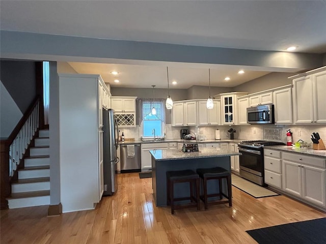563 W 9th St, Erie, PA 16502 - kitchen featuring stainless steel appliances, a kitchen island, a breakfast bar area, backsplash, and recessed lighting