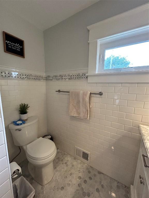 563 W 9th St, Erie, PA 16502 - bathroom featuring tile walls, vanity, wainscoting, and tile patterned flooring