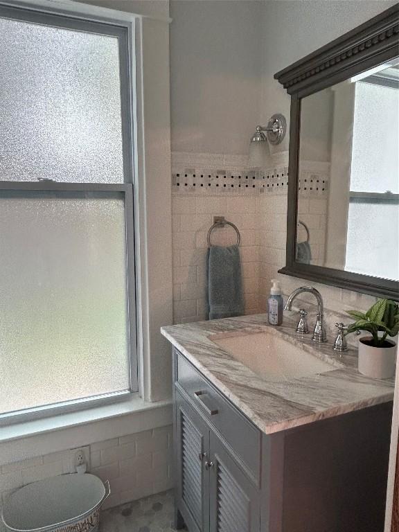 563 W 9th St, Erie, PA 16502 - bathroom with vanity, tile walls, and plenty of natural light