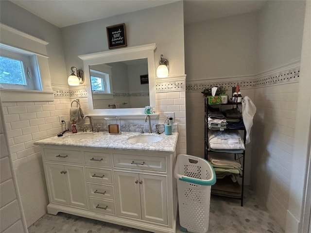 563 W 9th St, Erie, PA 16502 - bathroom featuring tile walls, double vanity, and wainscoting
