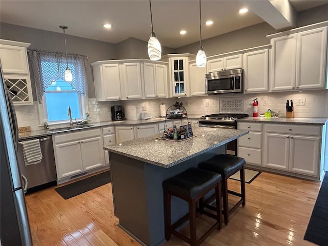 563 W 9th St, Erie, PA 16502 - kitchen with appliances with stainless steel finishes, a kitchen island, backsplash, white cabinetry, and recessed lighting