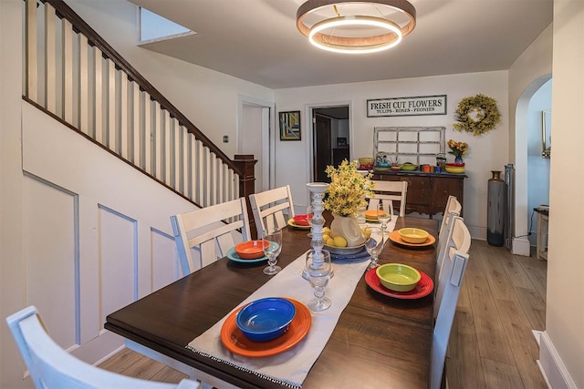 9 E Division St, North East, PA 16428 - dining space with arched walkways, wood finished floors, and stairs