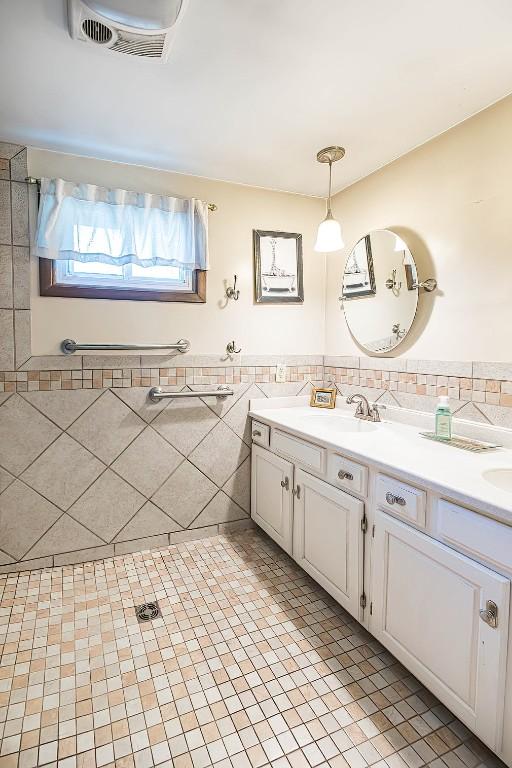 9 E Division St, North East, PA 16428 - bathroom with double vanity, tile walls, tile patterned flooring, and wainscoting