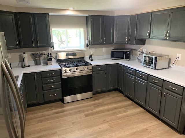 6028 Davidson Rd, Jamestown, PA 16134 - kitchen with stainless steel appliances, light countertops, and light wood-style flooring