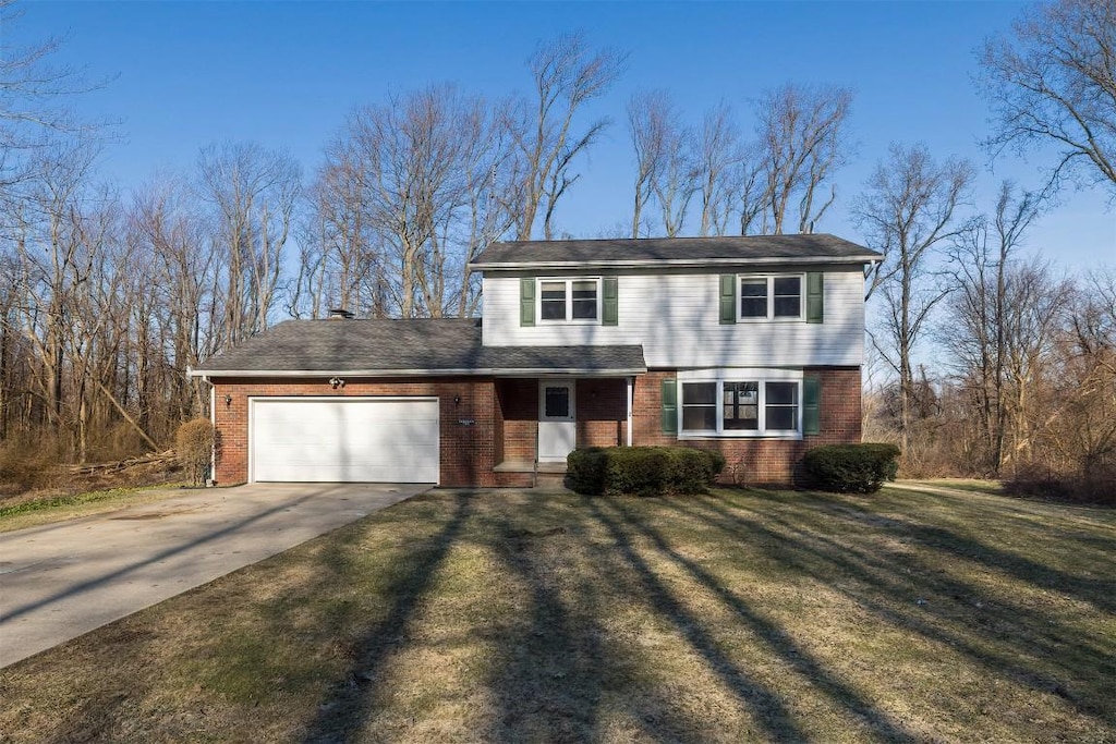 view of front facade with a garage, brick siding, concrete driveway, and a front lawn