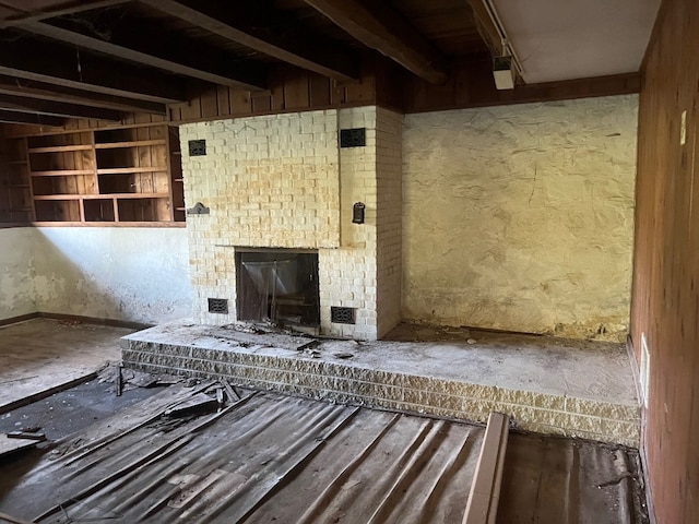 misc room featuring beamed ceiling and a fireplace