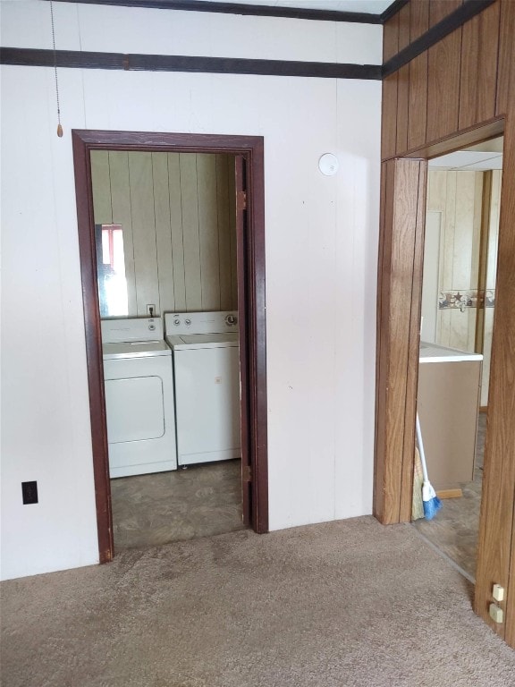 hall featuring washing machine and dryer, wooden walls, and carpet floors