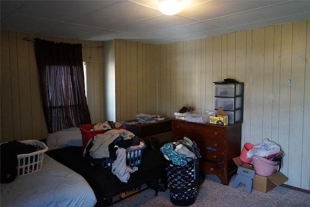 bedroom with carpet flooring and wood walls