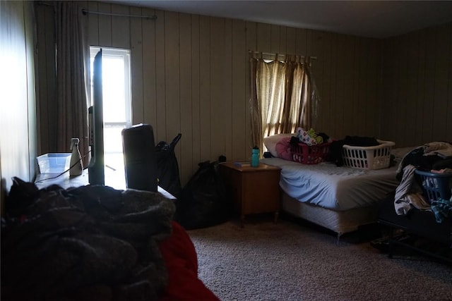 carpeted bedroom featuring wooden walls