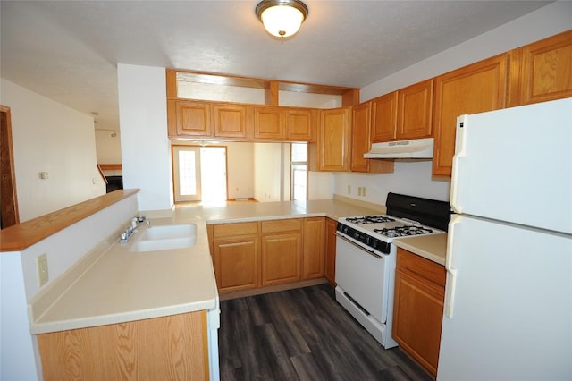 kitchen featuring sink, dark wood-type flooring, white appliances, and kitchen peninsula