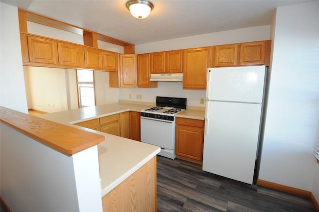 kitchen featuring white appliances, dark wood-type flooring, and kitchen peninsula