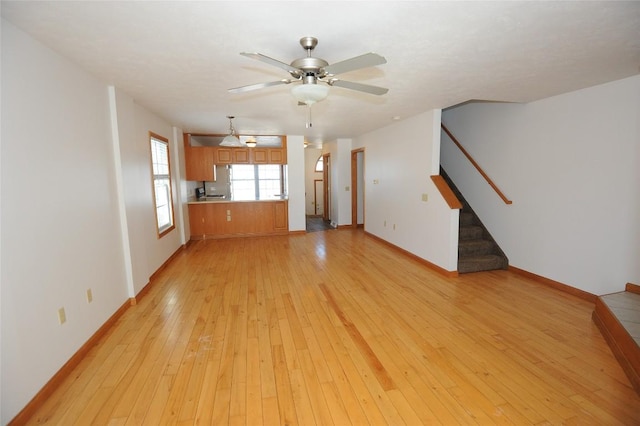 unfurnished living room featuring ceiling fan and light hardwood / wood-style floors