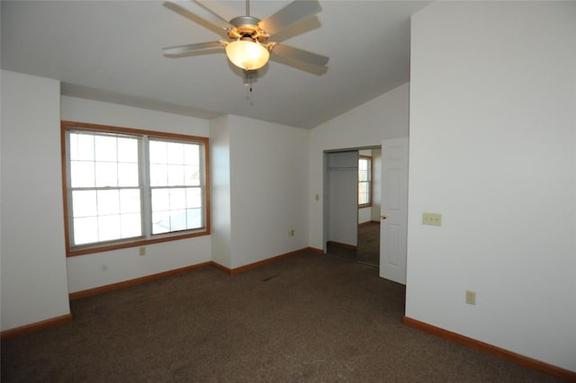 empty room featuring vaulted ceiling, ceiling fan, and dark colored carpet