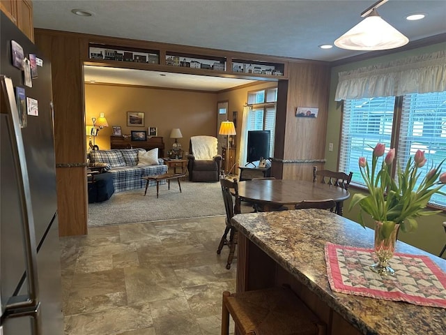 dining area featuring wood walls and crown molding