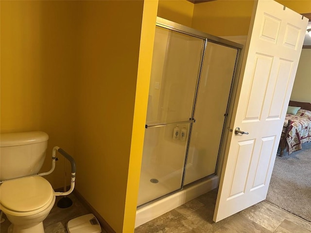 bathroom featuring toilet and a shower with shower door