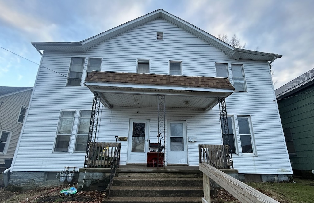 view of front of home with covered porch and roof with shingles