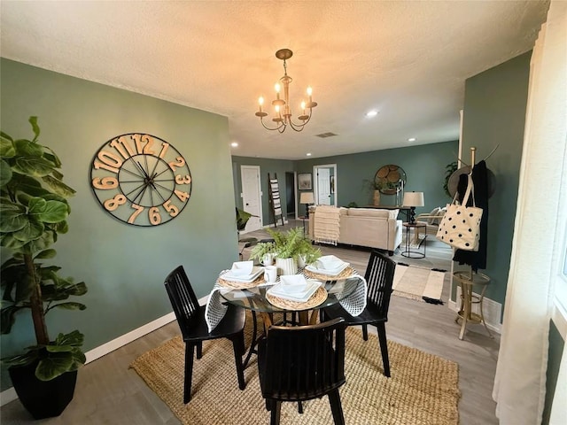 12013 Teifer Ave, Conneaut Lake, PA 16316 - dining room featuring a chandelier, wood finished floors, baseboards, and a textured ceiling
