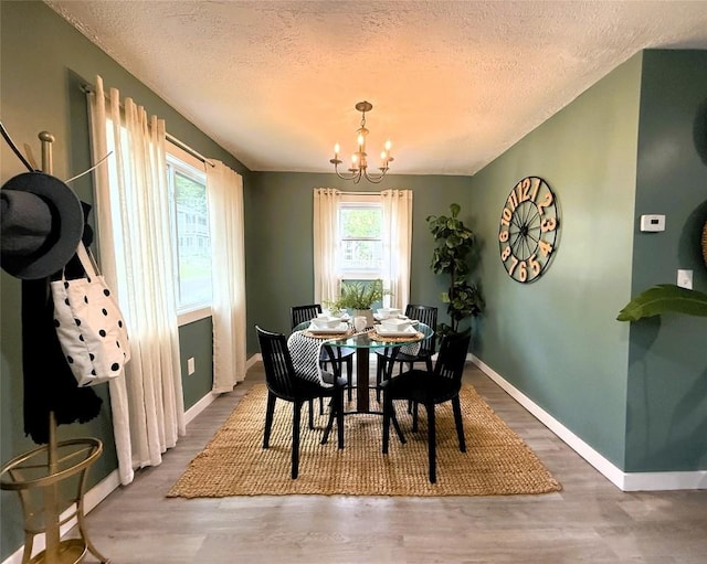 12013 Teifer Ave, Conneaut Lake, PA 16316 - dining space featuring a textured ceiling, a chandelier, baseboards, and wood finished floors