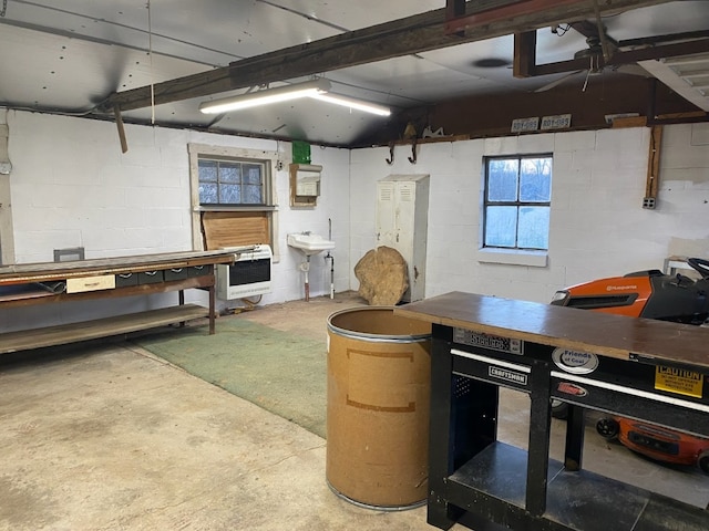 19437 Green Mountain St, Meadville, PA 16335 - basement featuring heating unit, a workshop area, a sink, ceiling fan, and concrete block wall
