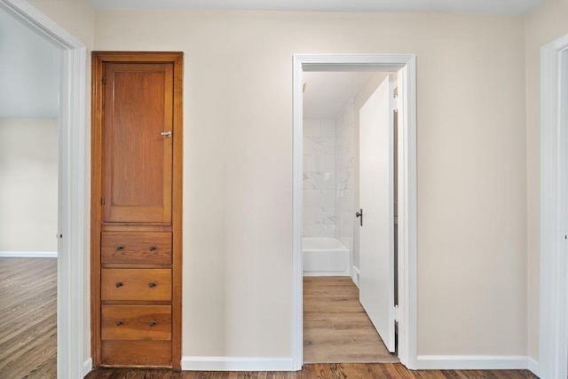 hallway with wood finished floors and baseboards