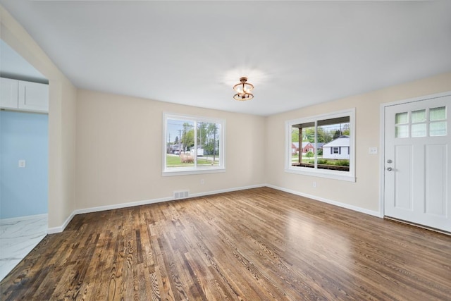 foyer entrance featuring dark wood-style floors and baseboards
