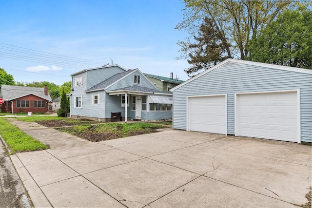 view of front of property featuring a detached garage and roof with shingles
