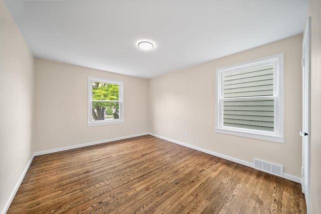 spare room featuring wood finished floors and baseboards