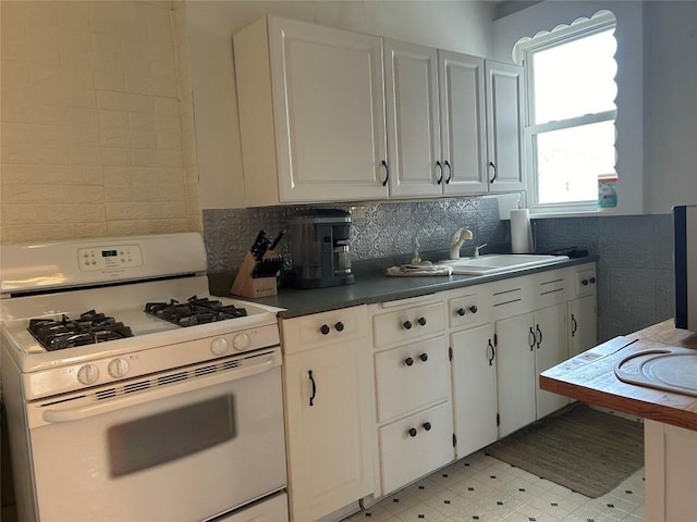 kitchen with white cabinetry, white range with gas stovetop, sink, and tasteful backsplash