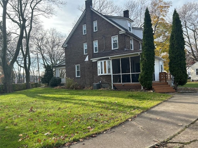 view of side of home featuring a lawn, central air condition unit, and a sunroom