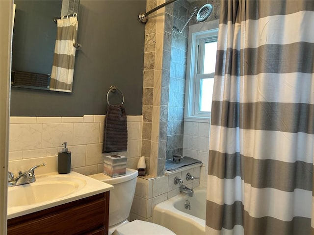 full bathroom featuring tasteful backsplash, toilet, shower / bath combo with shower curtain, vanity, and tile walls