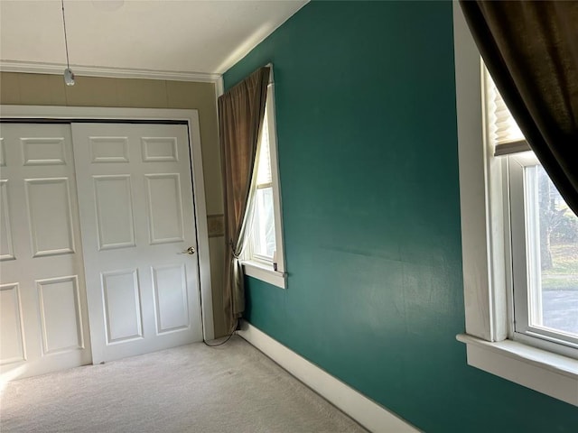 unfurnished bedroom with light carpet, a closet, and multiple windows