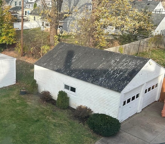 view of property exterior featuring a lawn, a garage, and an outdoor structure