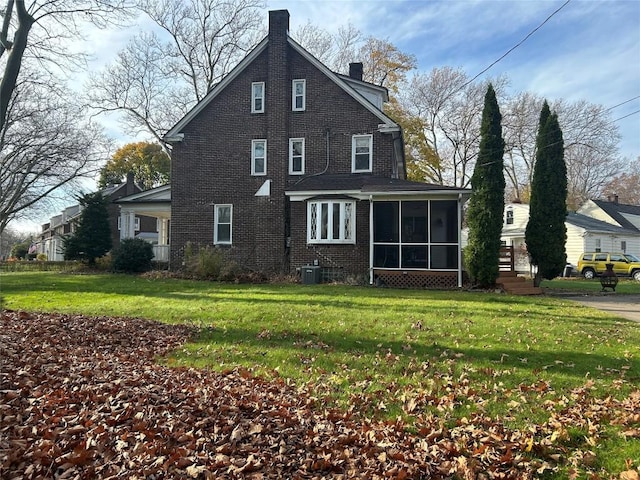 back of property with a lawn, a sunroom, and cooling unit