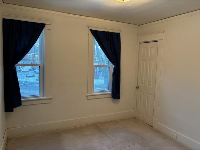 carpeted spare room featuring baseboards