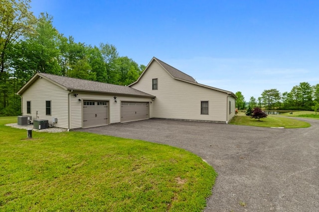 view of property exterior featuring a lawn, central AC, and a garage