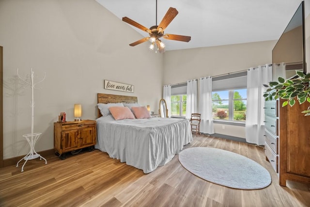 bedroom featuring hardwood / wood-style flooring, ceiling fan, and high vaulted ceiling