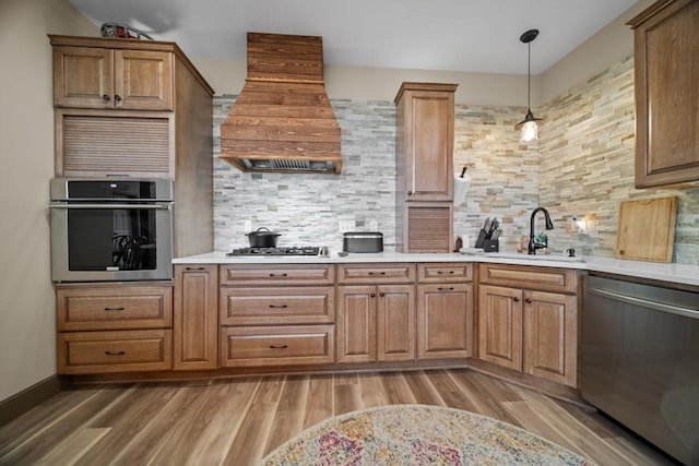 kitchen with premium range hood, sink, appliances with stainless steel finishes, and tasteful backsplash