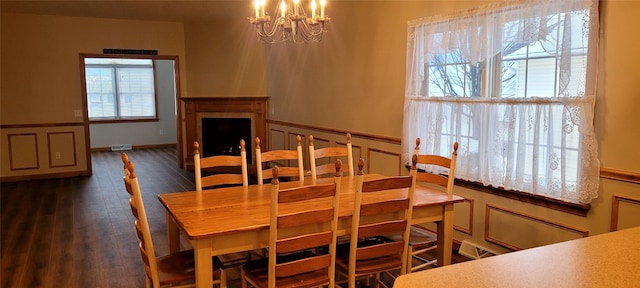 dining room with plenty of natural light, dark wood-type flooring, and a chandelier