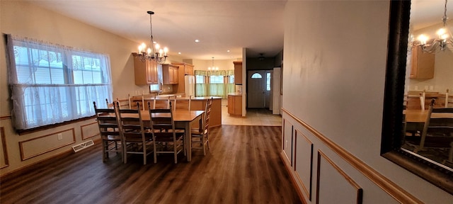 dining space featuring dark hardwood / wood-style flooring and a chandelier