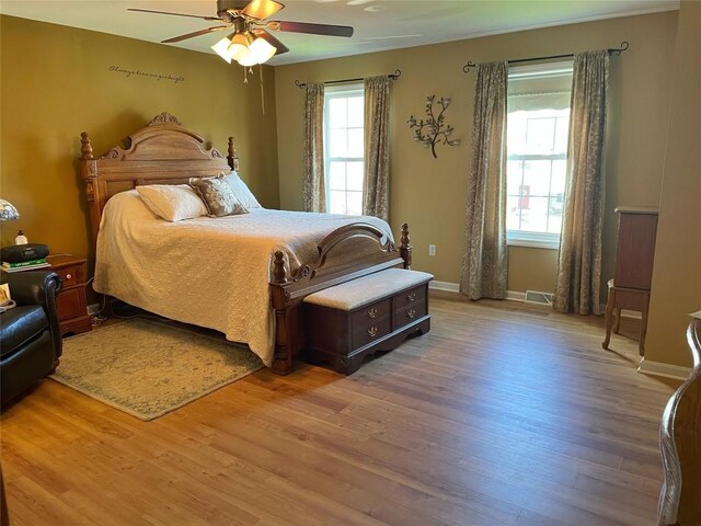 bedroom featuring light wood-type flooring, baseboards, and ceiling fan