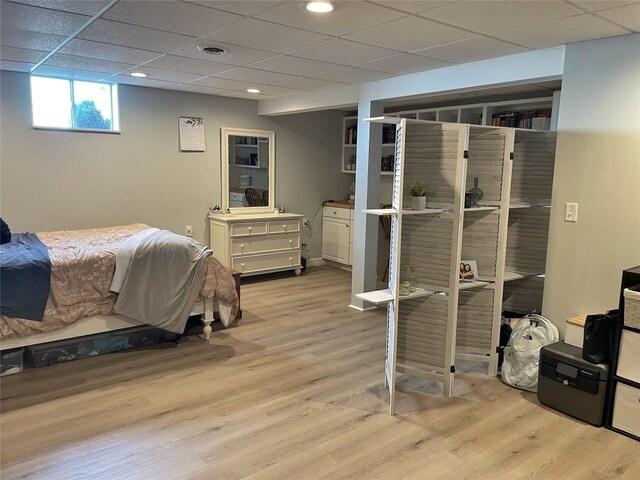 bedroom featuring light wood finished floors, a drop ceiling, and recessed lighting