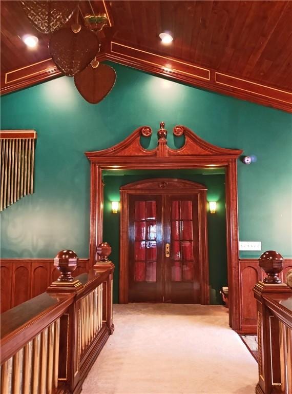 hallway with wooden ceiling, ornamental molding, light carpet, and vaulted ceiling