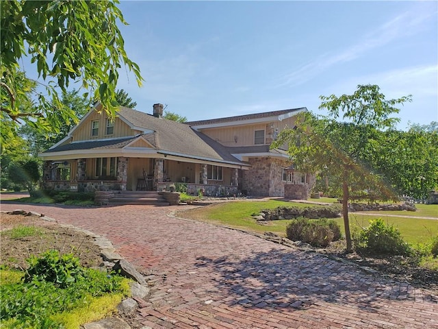 craftsman inspired home featuring covered porch and a front yard