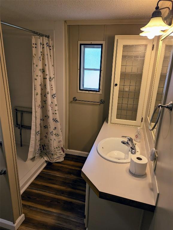 5005 Zuck Rd Unit 21, Erie, PA 16506 - bathroom featuring wood finished floors, vanity, a shower with curtain, a textured ceiling, and baseboards